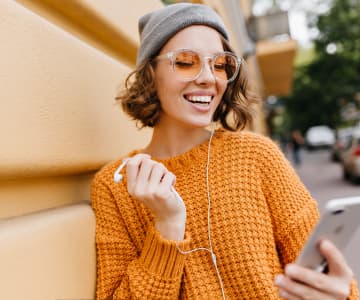 Girl with headphones watching on smartphone